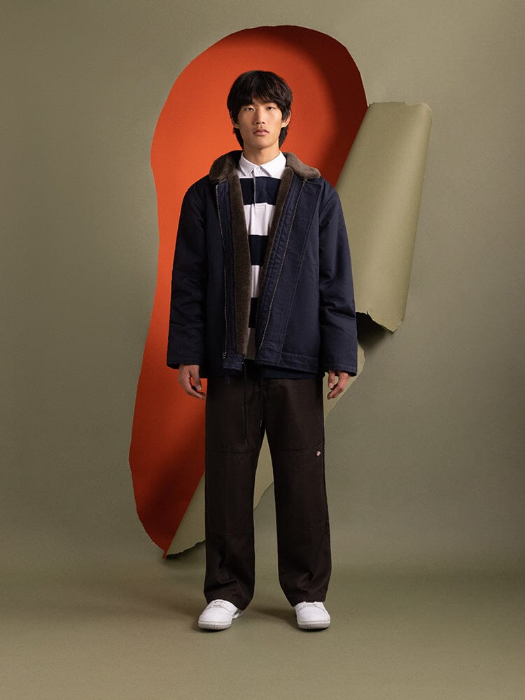 A person wearing the 1940s N-1 Deck Jacket in navy blue by Alpha Industries.