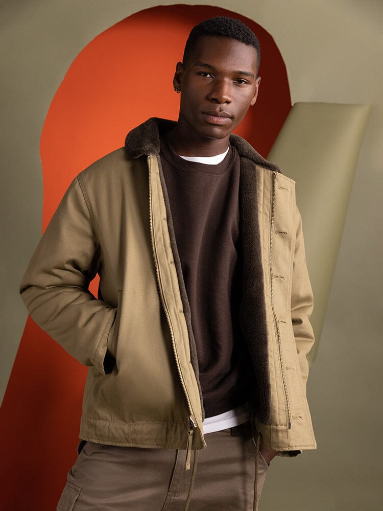 An individual dressed in an Alpha Industries 1940s N-1 Deck Jacket in khaki, featuring a cotton shell.
