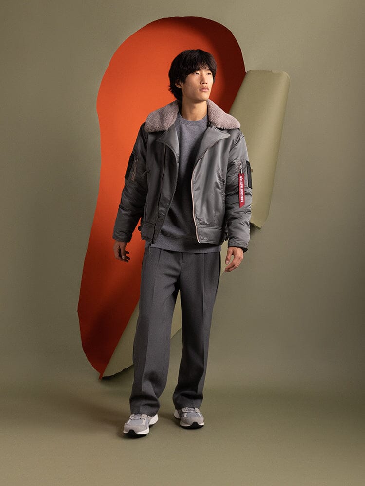 A person wearing the Alpha Industries 1960s RCAF Canadian Airforce Type III Jacket in field gray.