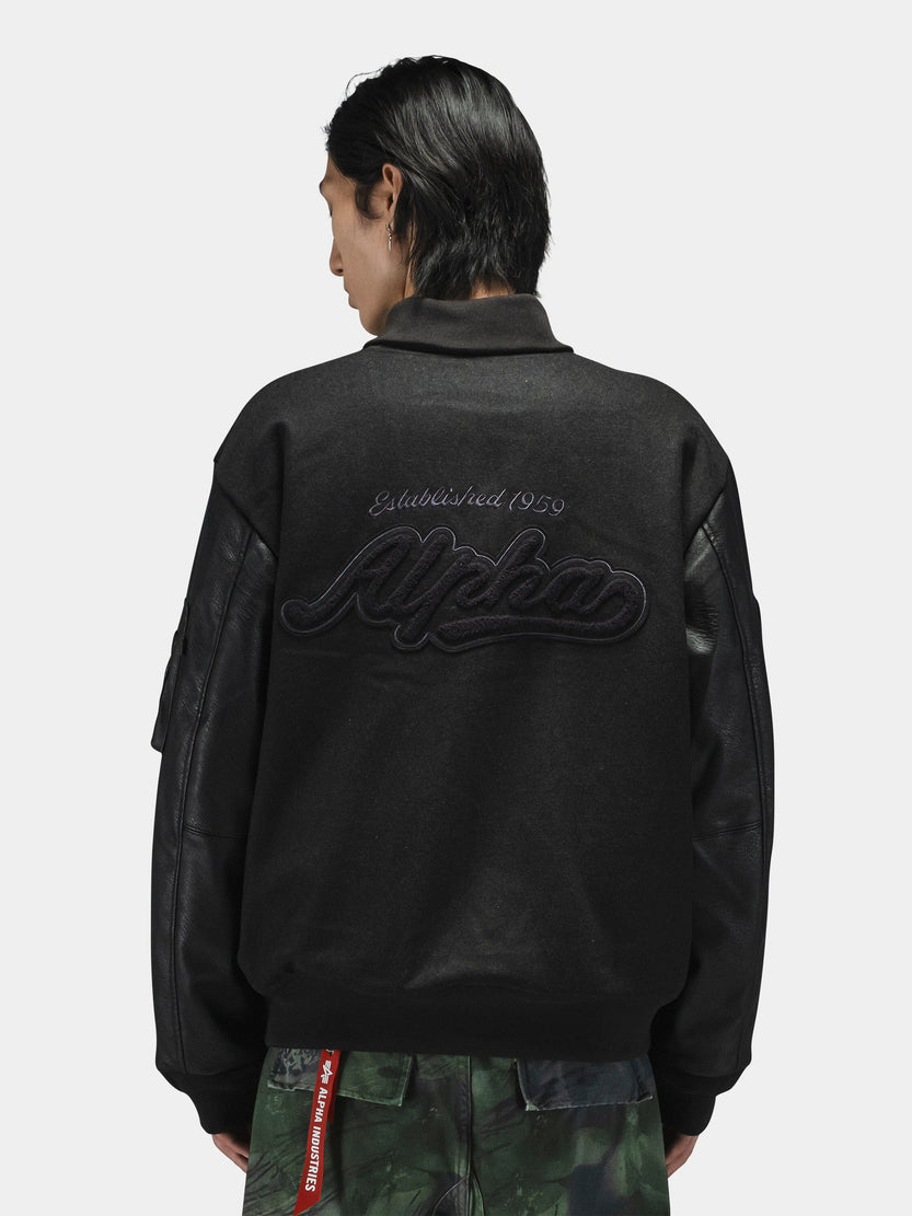Alpha Industries Alpha Letterman Jacket in black with camo pants; features include varsity-style design and front button closure.