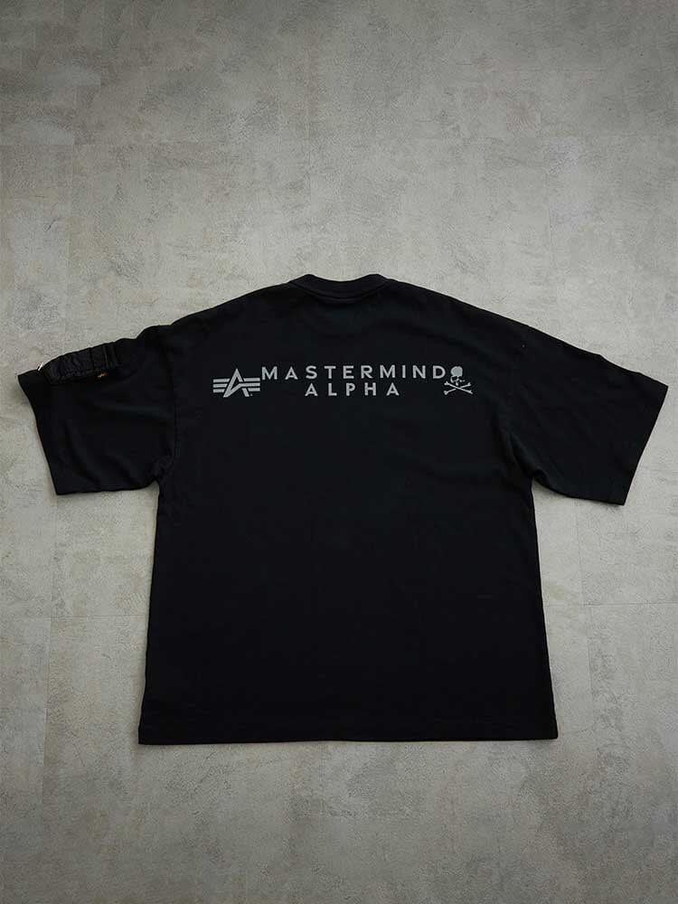 Alpha X Mastermind Tee by Alpha Industries, black, with Mastermind Alpha text, small skulls on upper back, left sleeve patch.