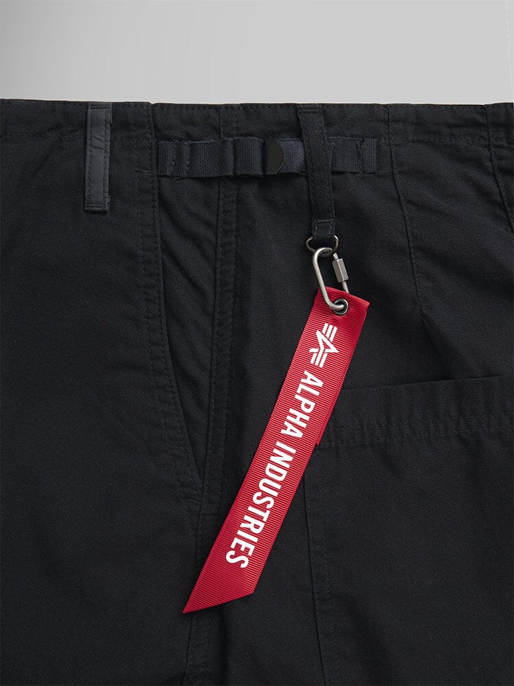 These Women's Barrel Leg Pants in black showcase a red Alpha Industries tag, attached to the pocket with a sleek metal clip.