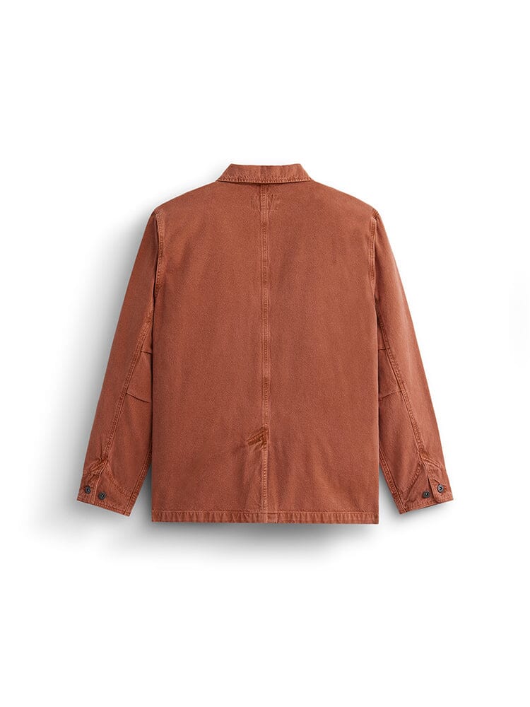 Alpha Industries Ctn Chore Coat, rust, long sleeves, buttoned cuffs, collar, visible seam details, nylon pocket accents.