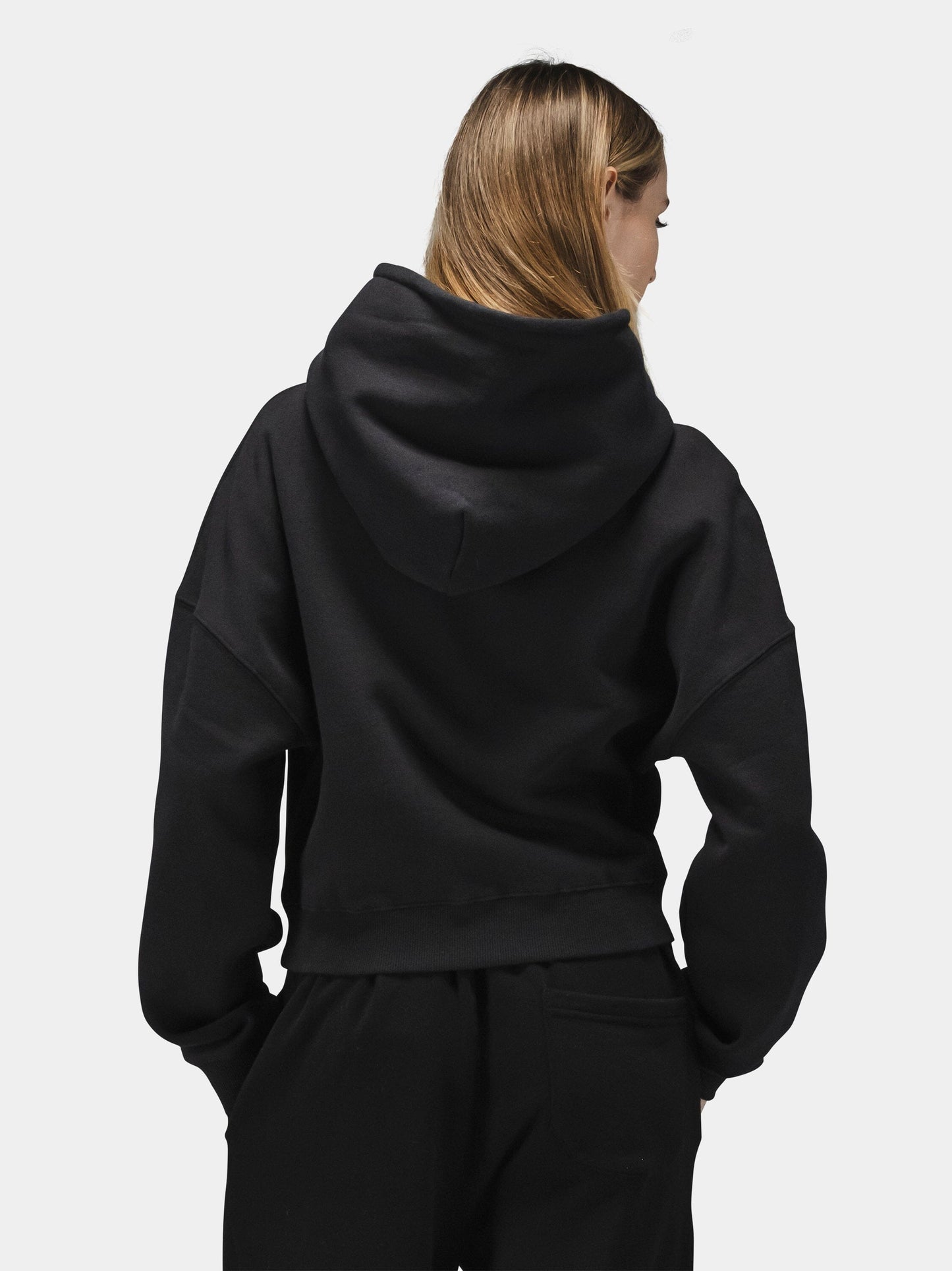 Alpha Industries Essential Cropped Hoodie Womens in black with embroidered logo, paired with black pants.