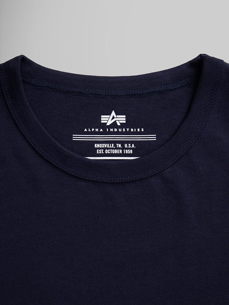 Collar and label of navy blue Alpha Industries Essential Relaxed Tee with brand logo, Knoxville, TN, U.S.A., established October 1959.