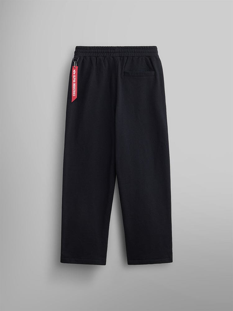 The Women's Essential Sweatpants from Alpha Industries are designed in black, crafted from soft cotton fabric. They feature an elastic waist and a side logo tag.