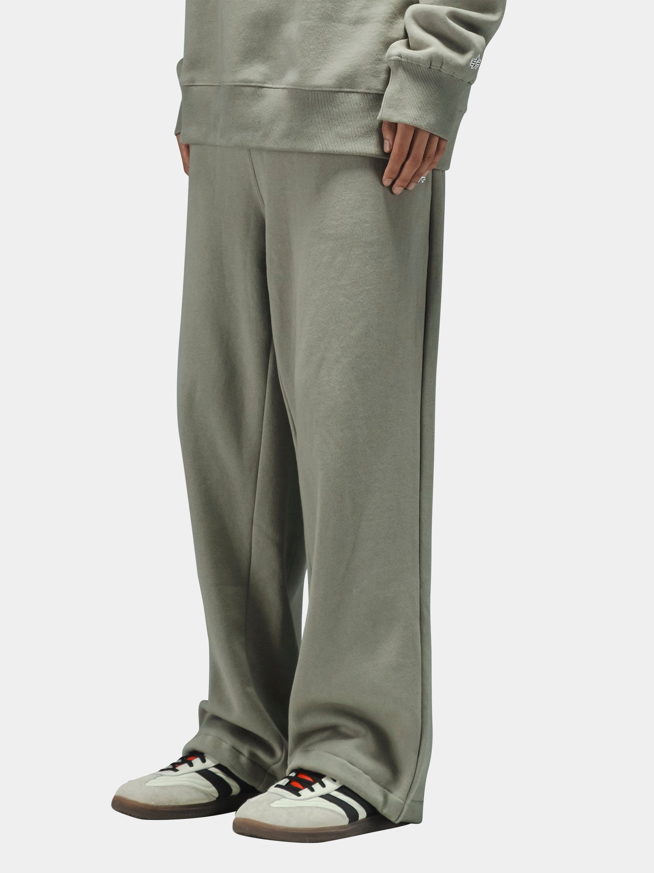 Alpha Industries Essential Sweatpants in matching set, white sneakers with black and red accents.