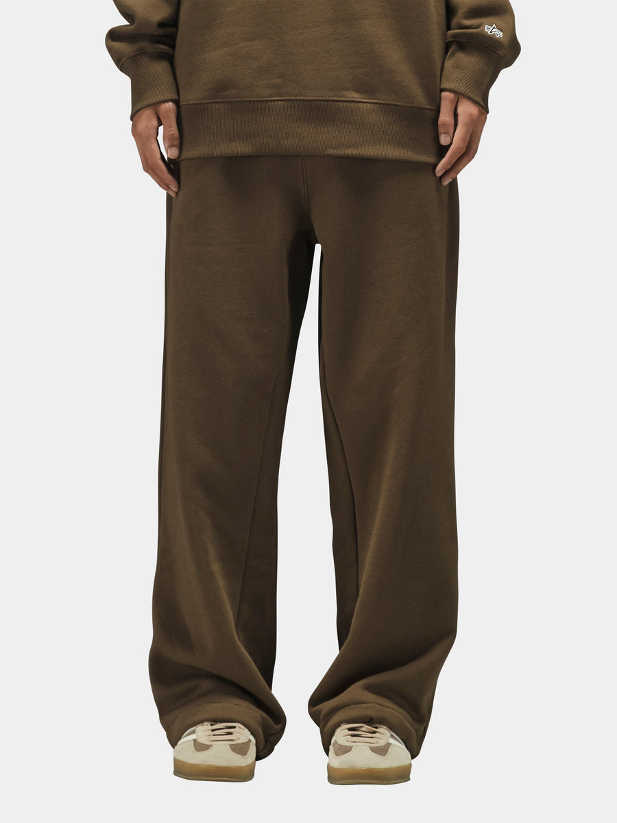 Alpha Industries Essential Sweatpants in black, paired with beige sneakers.