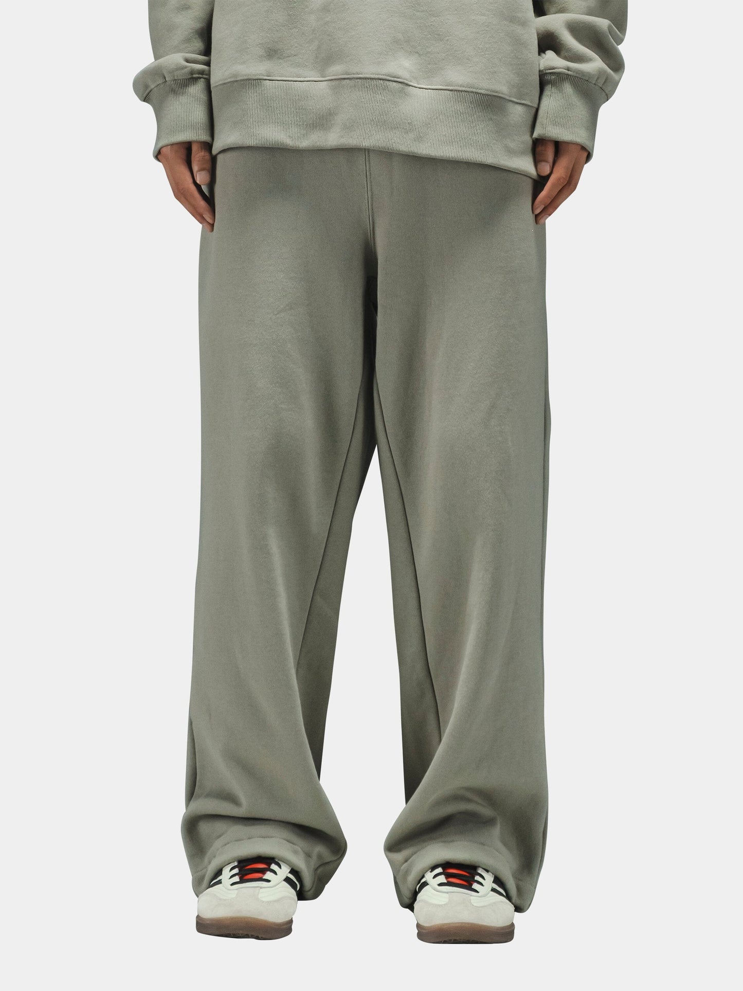 Alpha Industries Essential Sweatpants in light gray with matching sweatshirt and white sneakers with colored accents.
