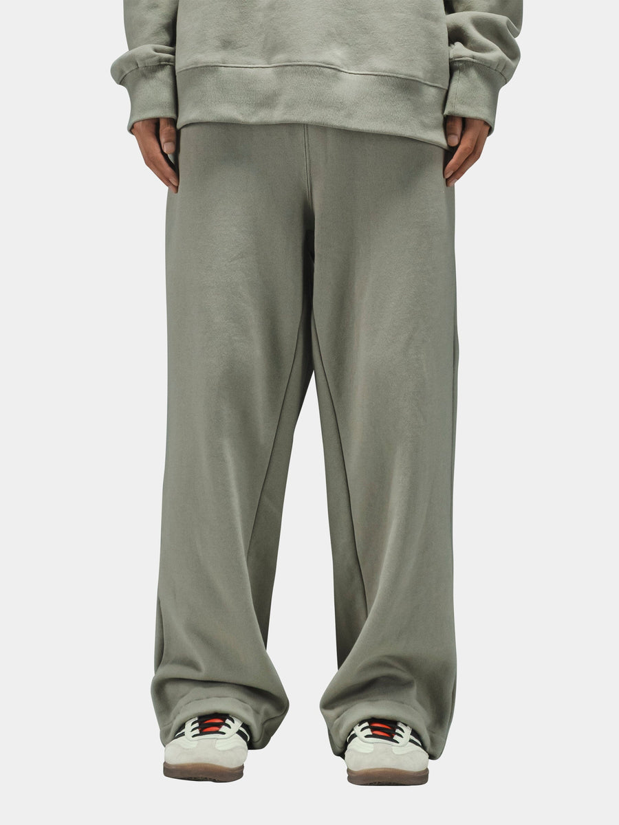 Alpha Industries Essential Sweatpants in light gray with matching sweatshirt and white sneakers with colored accents.