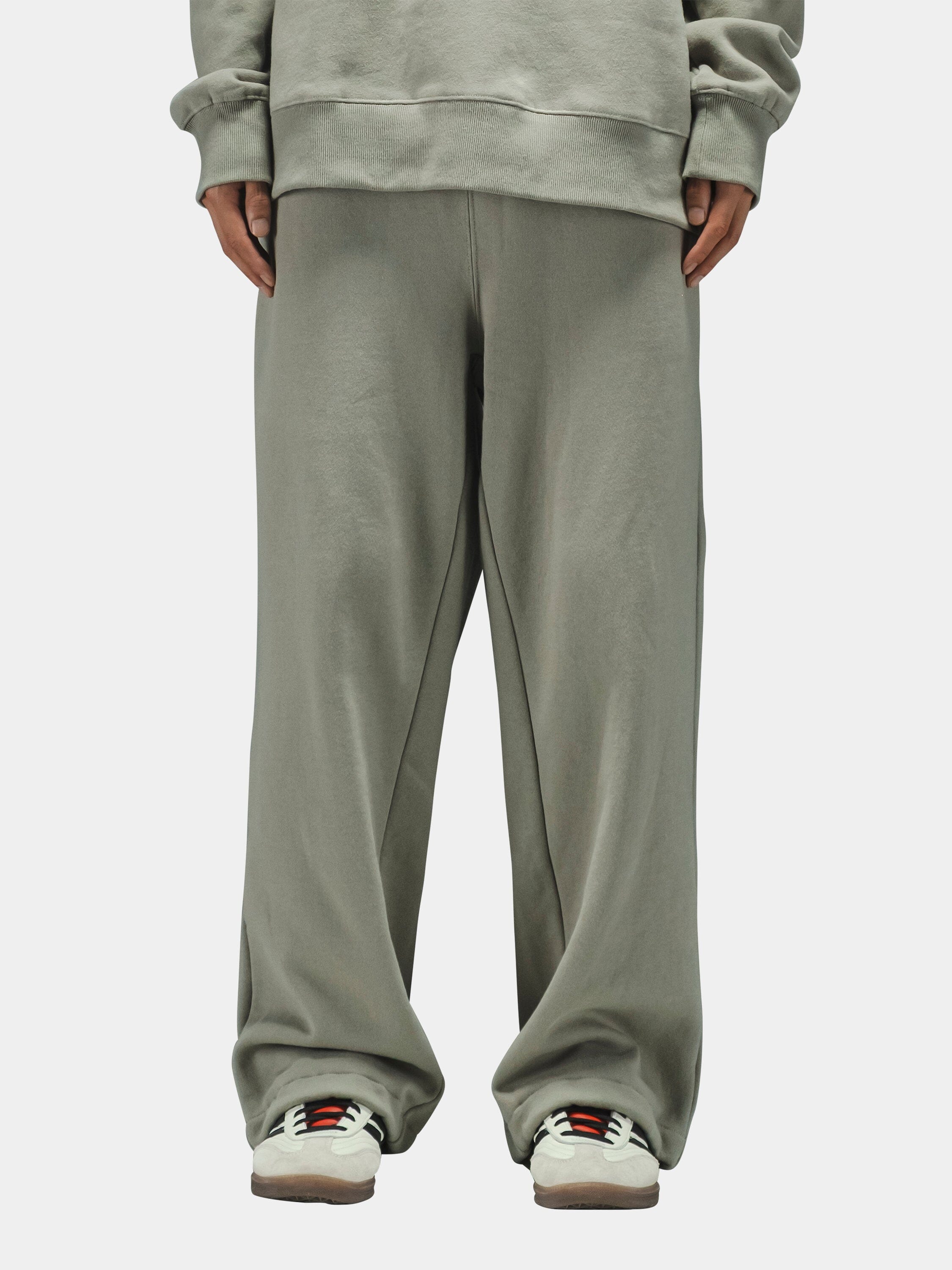 Alpha Industries Essential Sweatpants in light gray with matching sweatshirt and white sneakers with colored accents.