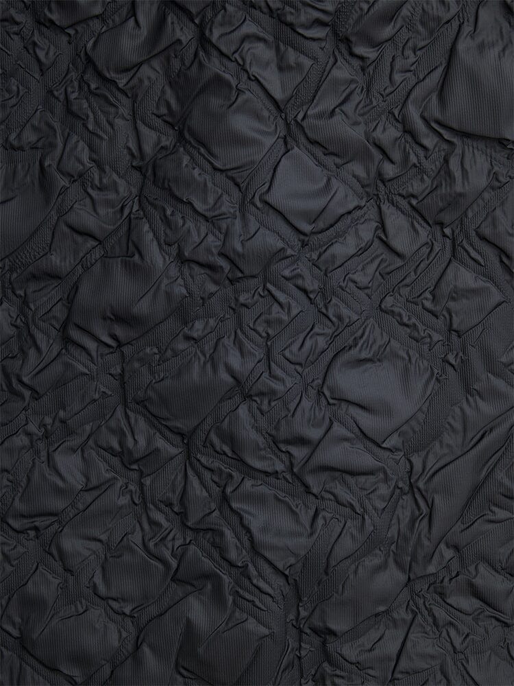 Alpha Industries L-2B Bubble Flight Jacket, black outer shell, crumpled texture with irregular lines and geometric creases.