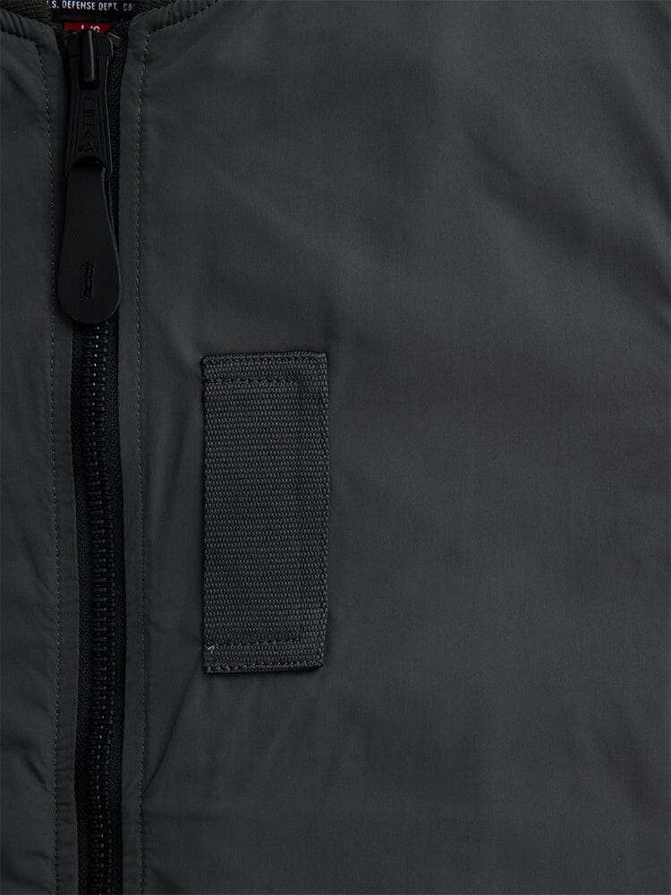 Alpha Industries L-2B Paratrooper Flight Jacket in dark green, black zipper, rectangular black fabric patch, subtle onion quilting details.