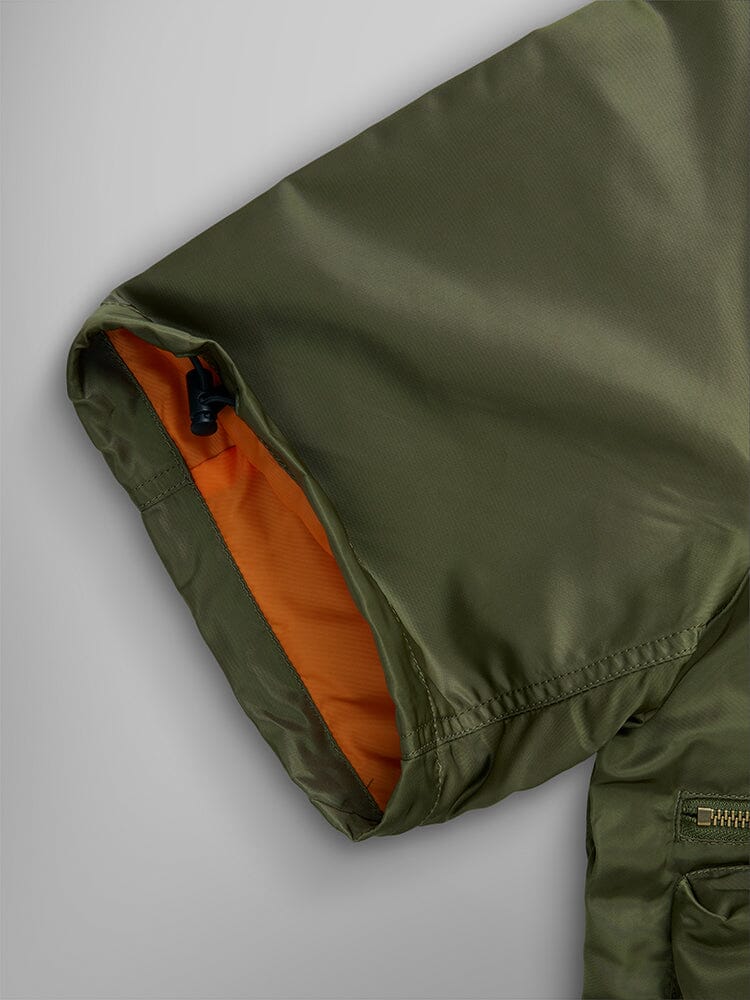 Alpha Industries L-2B Short Sleeve Bomber Jacket, olive green water-resistant nylon, orange lining, zippered utility pocket.