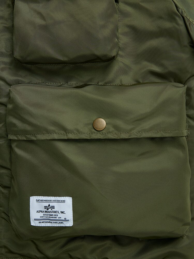 Alpha Industries L-2B Short Sleeve Bomber Jacket, olive green nylon, snap-button utility pocket, small upper pocket, white Alpha Industries label on lower left corner.