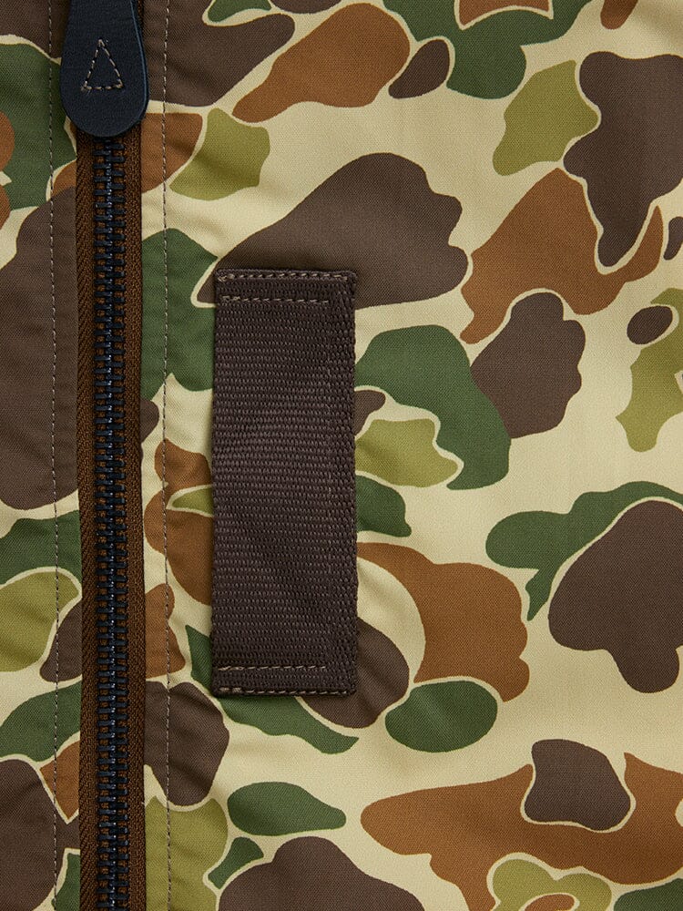 Close-up of the L-2B Skymaster Gen II Bomber Jacket by Alpha Industries, Inc. highlighting a green, brown, and beige camouflage pattern with a vertical brown strap and zipper. This water-resistant nylon jacket blends style and functionality for adventurous outdoor activities.