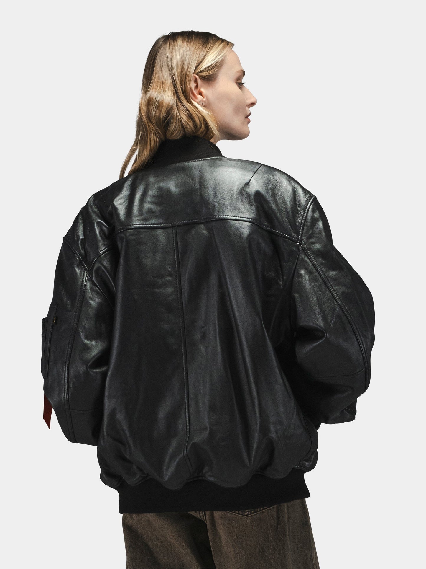 Black Leather MA-1 Flight Jacket by Alpha Industries with brown pants.