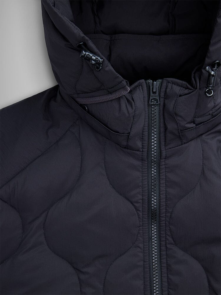 Close-up of the Lightweight Quilted Down Jacket in black by Alpha Industries, featuring a partially closed zipper that highlights the removable hood and intricate seam details.