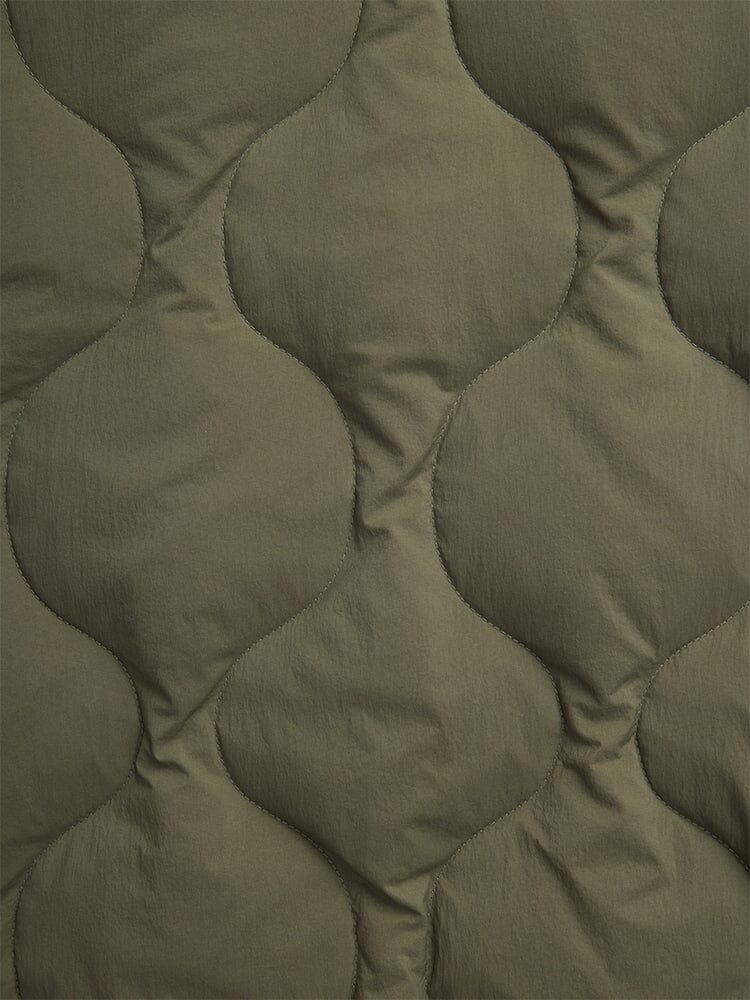 Close-up of the Alpha Industries Lightweight Quilted Down Jacket in olive green, featuring a wavy padded pattern.