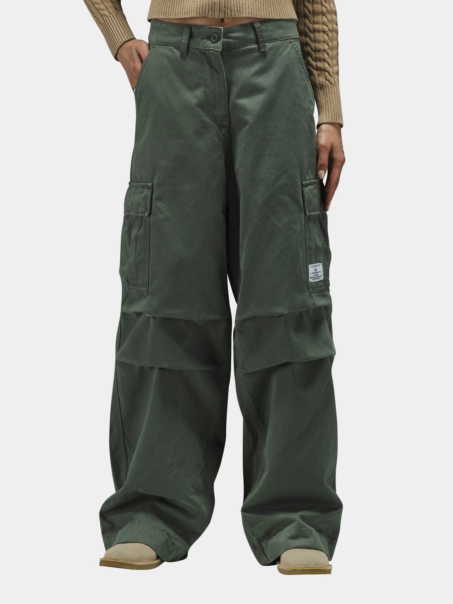 Alpha Industries M-65 Cargo Pant Womens, olive green, high-waisted, wide-leg with patch pockets, paired with beige ribbed sweater.
