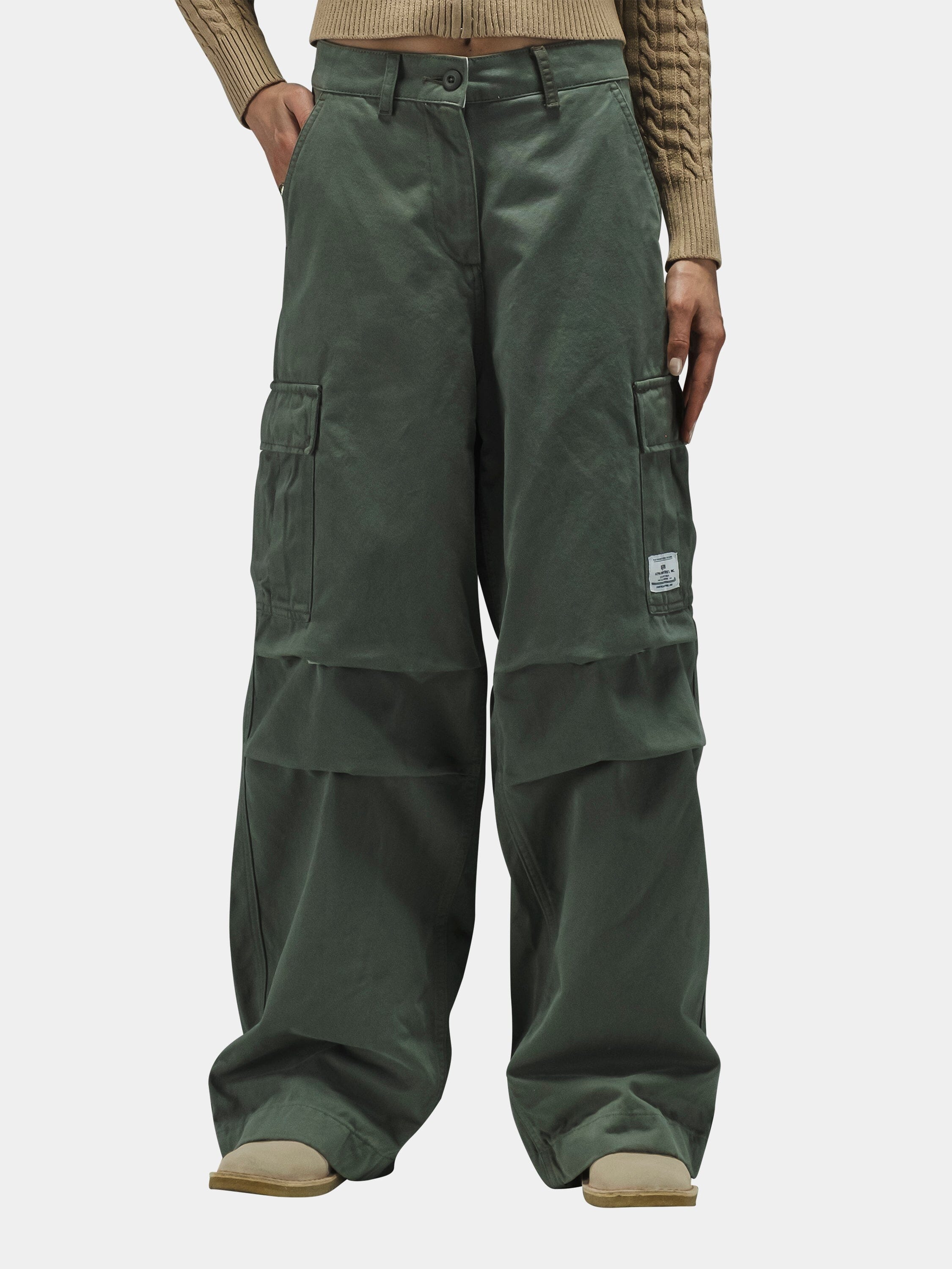 Alpha Industries M-65 Cargo Pant Womens, olive green, high-waisted, wide-leg with patch pockets, paired with beige ribbed sweater.