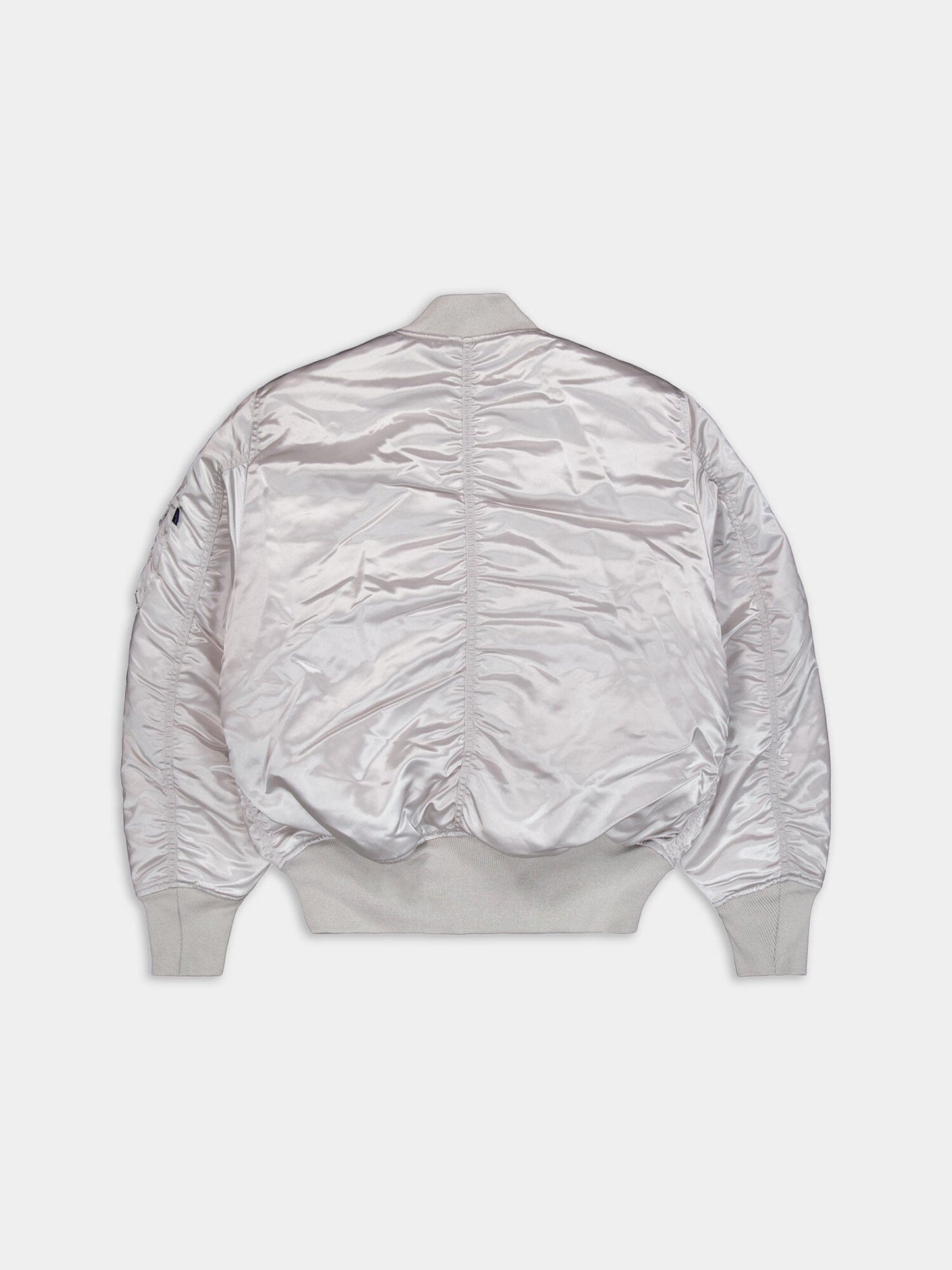 Alpha Industries MA-1 jacket with silver satin finish, ribbed cuffs, hem, and collar, slightly wrinkled texture.