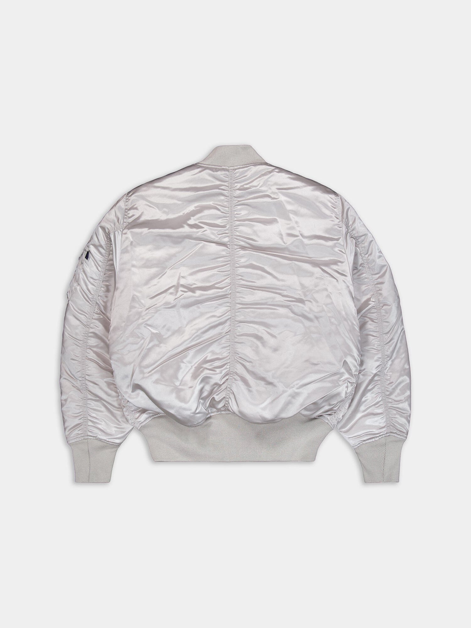 Alpha Industries MA-1 jacket with silver satin finish, ribbed cuffs, hem, and collar, slightly wrinkled texture.