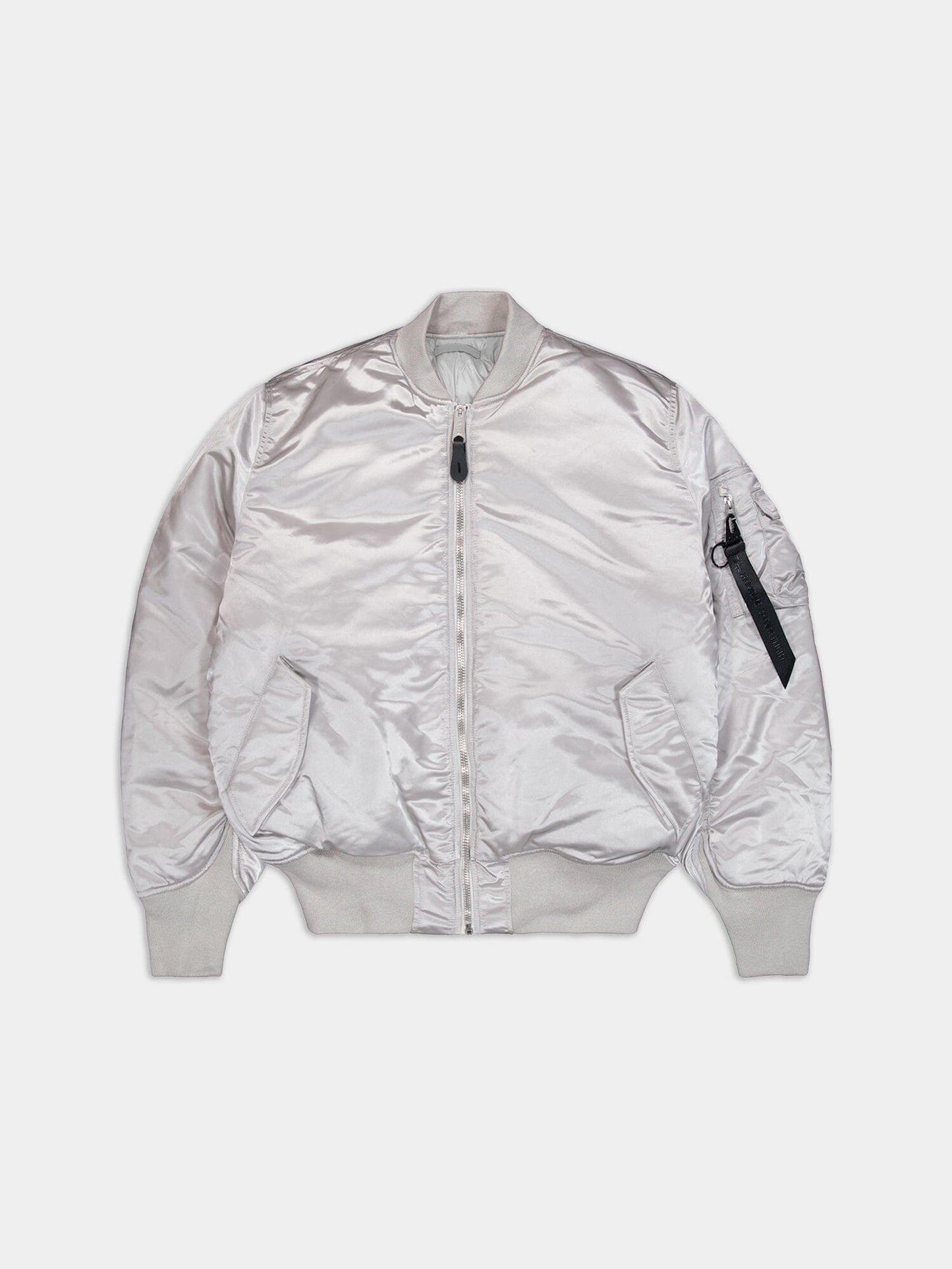 Alpha Industries MA-1 jacket in shiny silver with front zip, ribbed cuffs and hem, two front pockets, and a sleeve zip pocket.