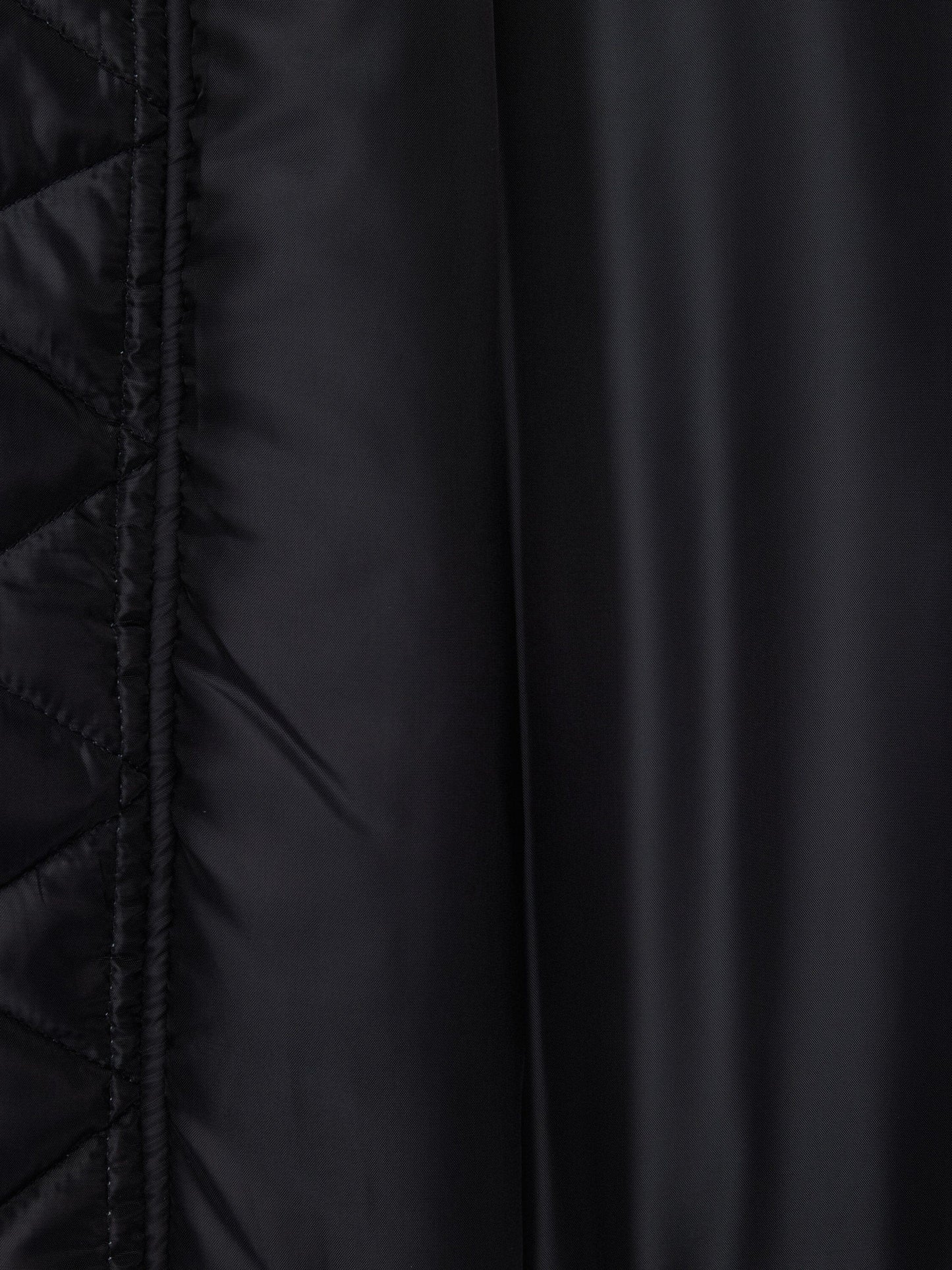 Alpha Industries MA-1 Oxford Flight Jacket, black oxford nylon with quilted pattern left, smooth finish right, visible stitching.