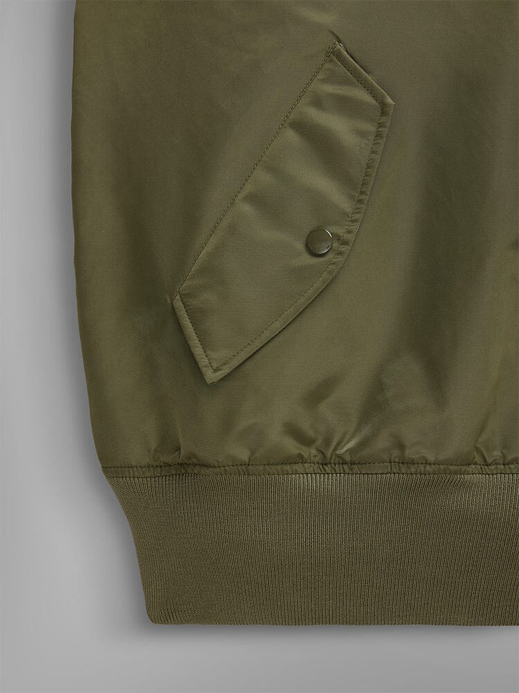 Close-up of the pocket from the Pull-Over MA-1 Jacket Hoodie in olive green by Alpha Industries, highlighting a buttoned utility pocket and elastic hem.