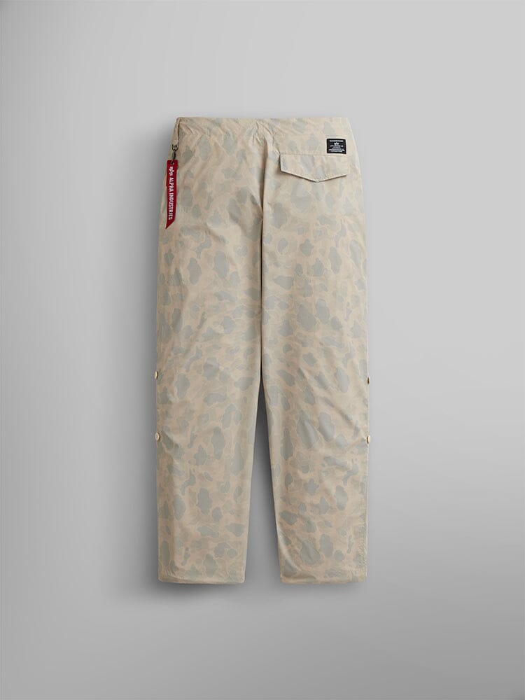 Alpha Industries Lightweight Parachute Pant in beige camo, ripstop fabric, rear pocket, MA-1 red keychain tag on waistband.