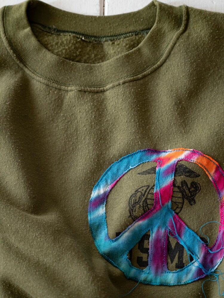 Transnomadica X Alpha Upcycled USMC Sweatshirt by Alpha Industries, olive, faded emblem, tie-dyed peace sign patch, blue thread accents.