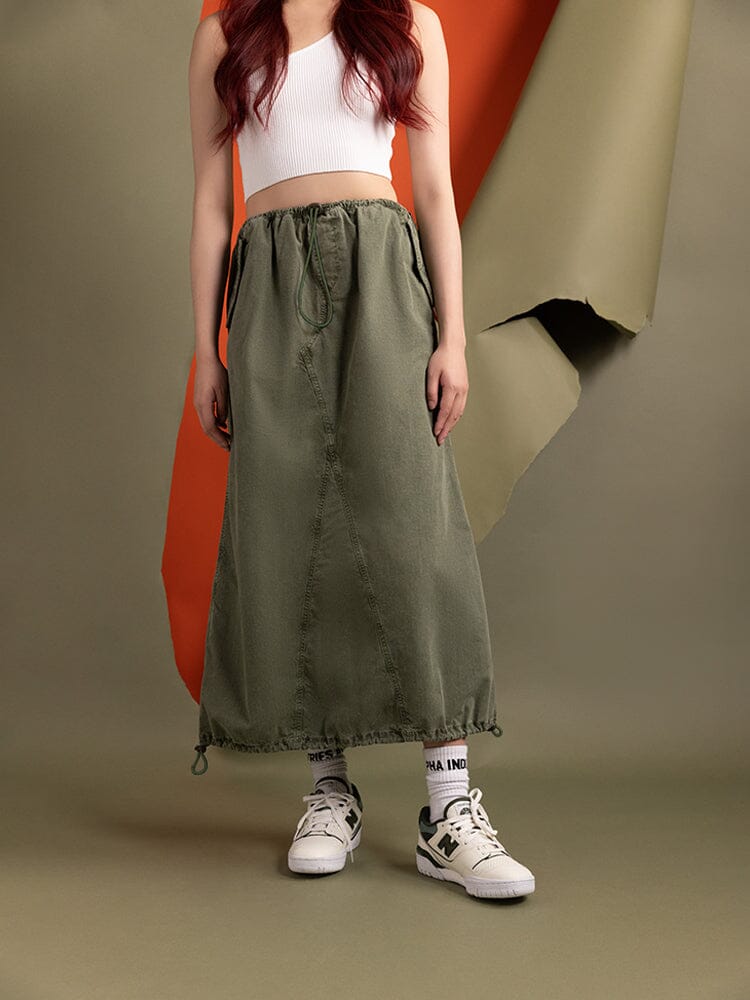 A person in the green Women's Drawcord Skirt by Alpha Industries.