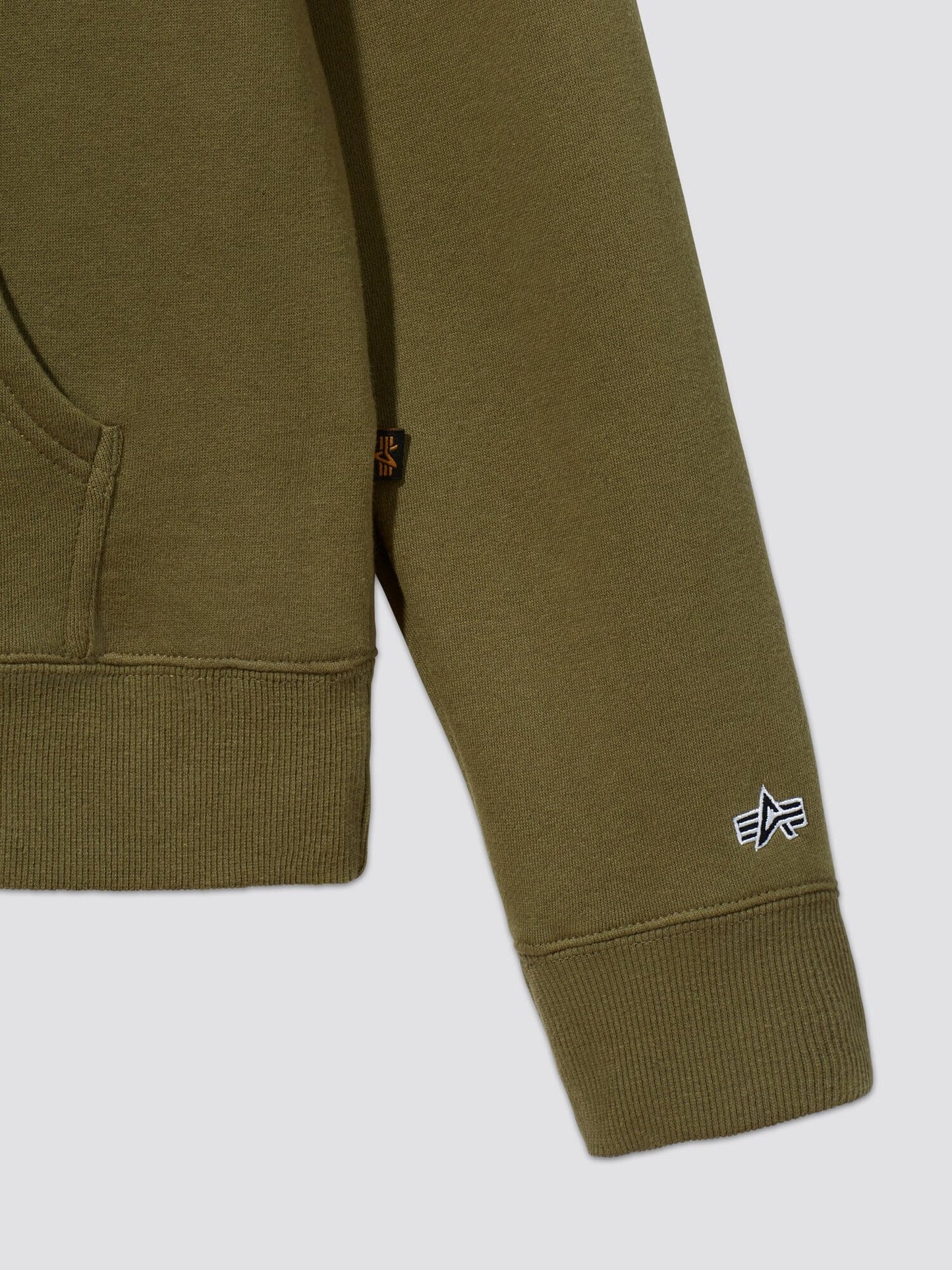 Close-up of an olive green Alpha Hoodie sleeve, featuring a small embroidered star logo in white. Crafted from soft cotton fabric by Alpha Industries, Inc., it showcases a visible pocket seam.