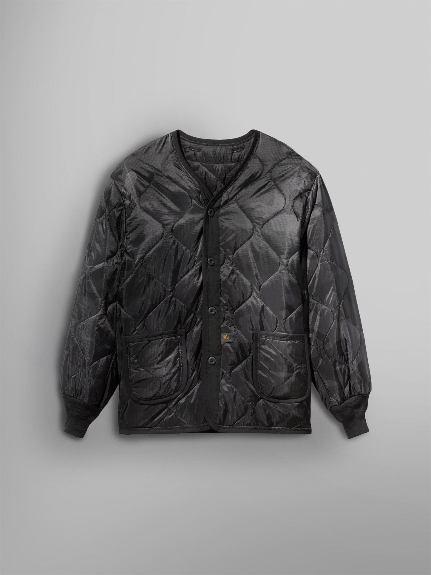 Alpha Industries ALS/92 Liner in Black Woodland Camo, quilted design, two front pockets, ribbed cuffs.