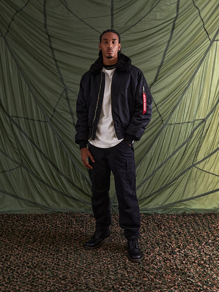 Alpha Industries B-15 Bomber Jacket in green with water resistance, MA-1 utility pocket, and removable faux-mouton collar.