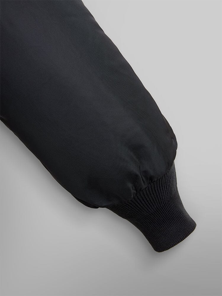 Alpha Industries B-15 Bomber Jacket sleeve in black with water-resistant fabric and ribbed cuff.