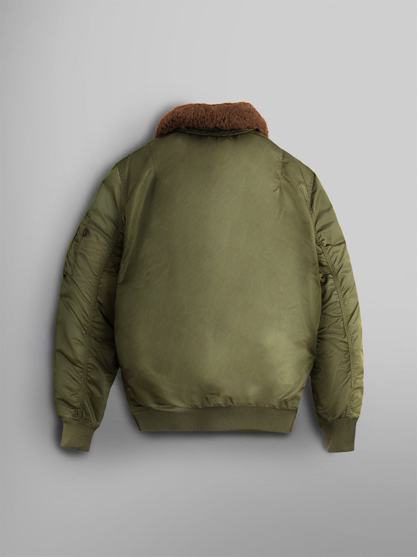 Alpha Industries B-15 Mod Bomber Jacket in olive green with brown faux mouton collar, ribbed cuffs, and waistband.