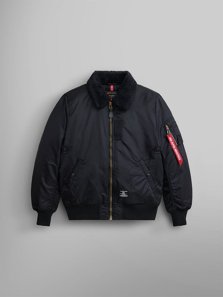 Alpha Industries B-15 Mod Bomber Jacket in black with faux mouton shearling collar, front zipper, ribbed cuffs and hem, red tag.