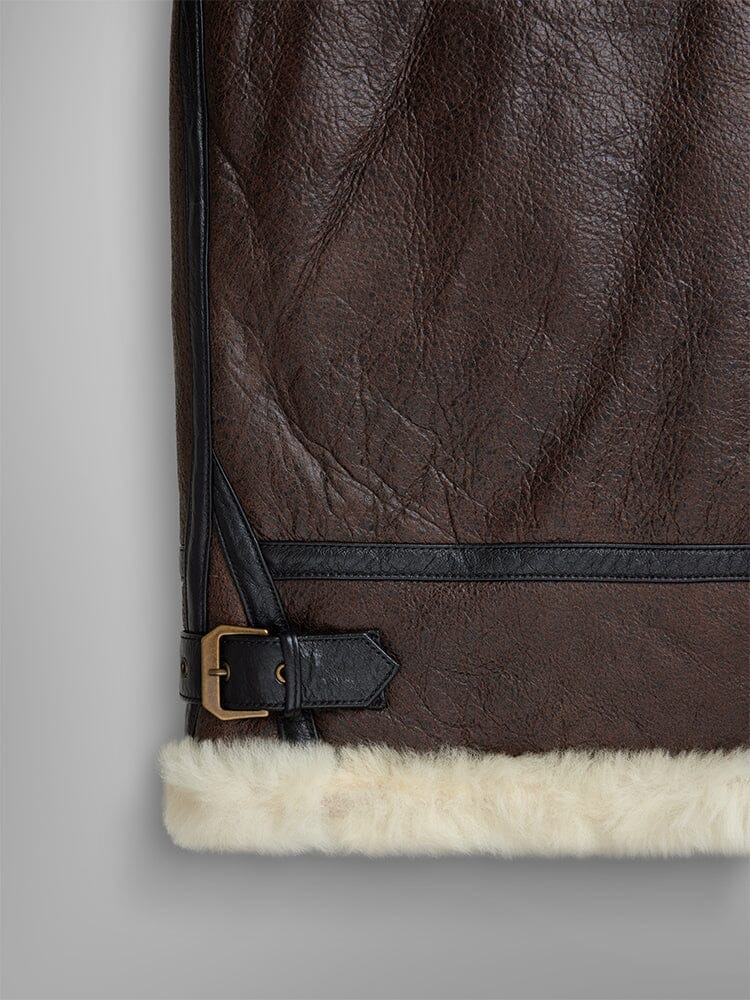 Alpha Industries B-3 Sherpa Leather Bomber Jacket, black strap and buckle detail, white sheepskin trim along bottom edge.