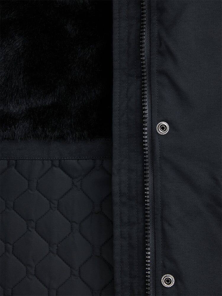 Close-up of the Elyse Gen II Parka W in black by Alpha Industries, highlighting a quilted pattern, faux fur lining, and a vertical zipper with metal snap buttons.