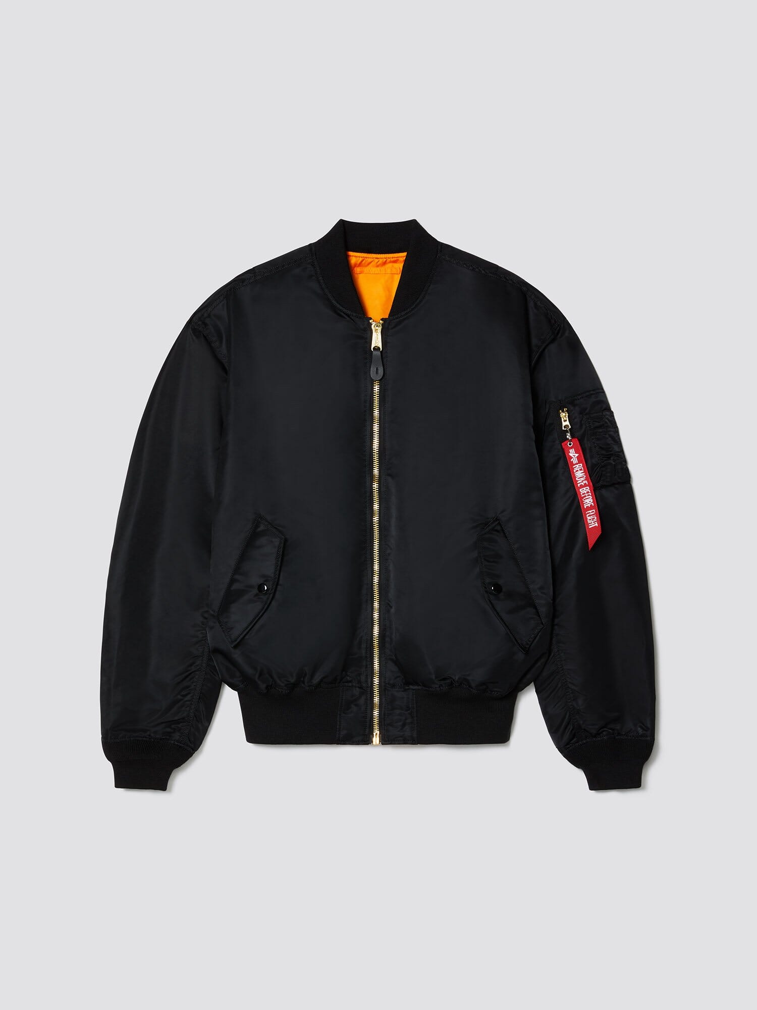 Alpha Industries L-2B Loose Bomber Jacket, black, water-resistant, front zipper, ribbed cuffs and hem, two side pockets, orange lining, red tag on sleeve zipper pocket.