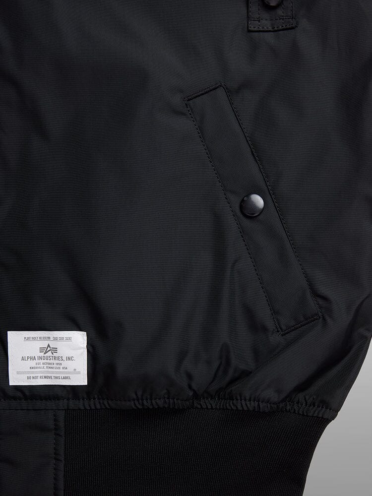 L-2B Skymaster Gen II Bomber Jacket by Alpha Industries, black nylon, slanted snap-button pocket, ribbed hem, white Alpha Industries label near waistband.
