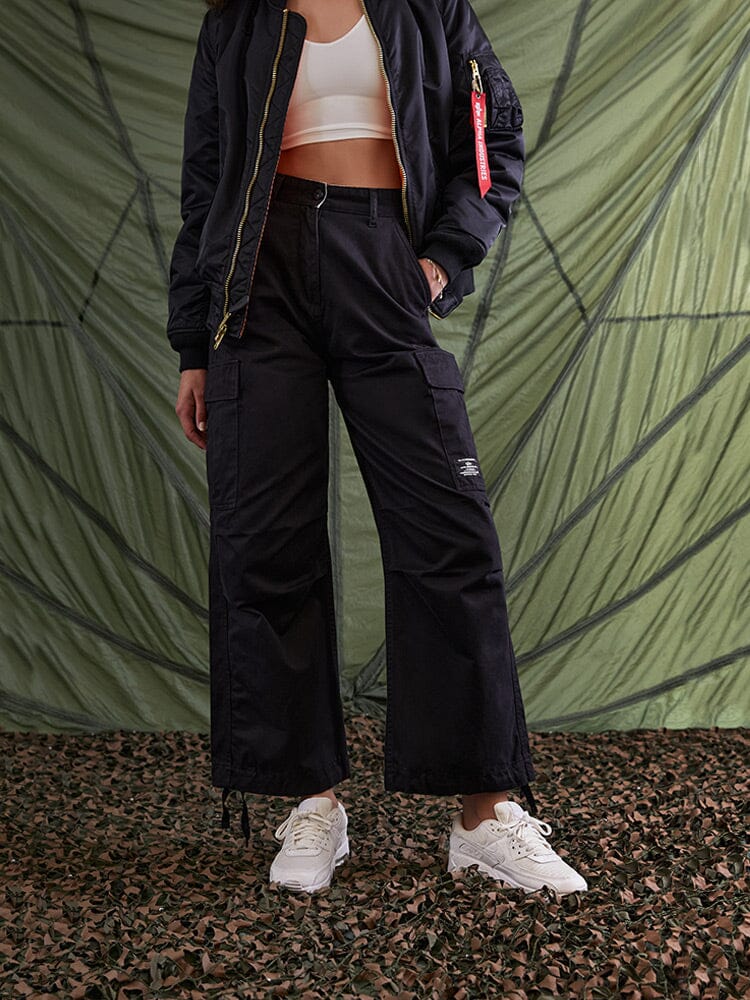 Black bomber jacket, white crop top, Alpha Industries M-65 Cargo Pant Womens in black, white sneakers.