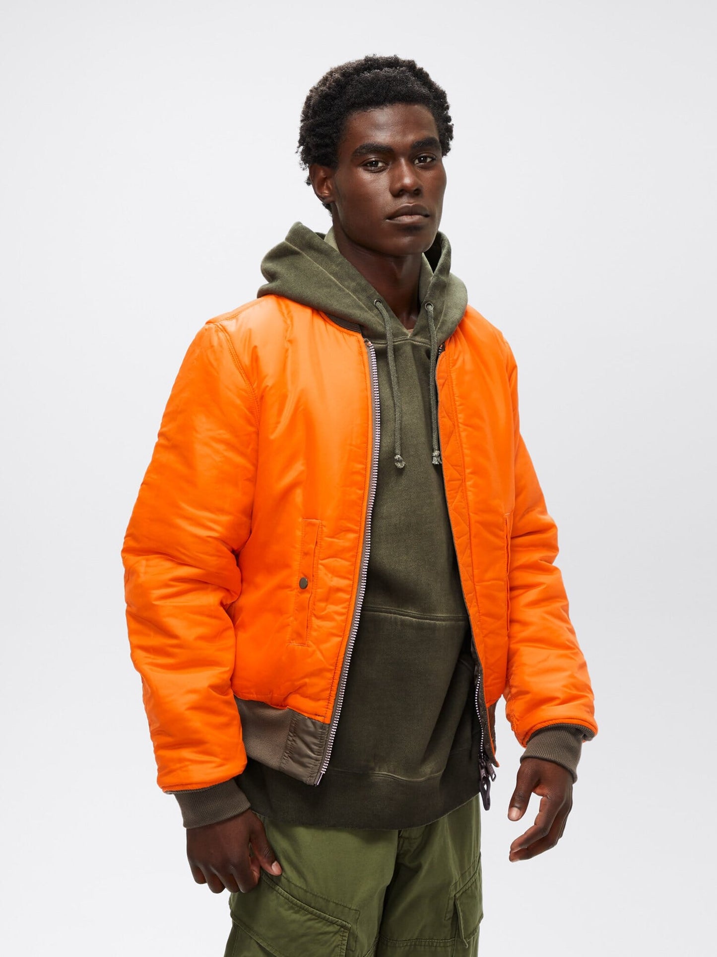 Three-quarter front view of orange reversible Alpha Industries MA-1 Bomber Jacket Slim Fit showing ribbed cuffs and waistband.