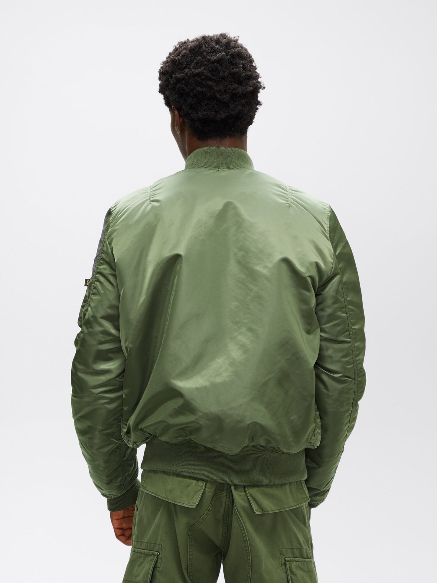 Full-body back view of sage green Alpha Industries MA-1 Bomber Jacket Slim Fit showing ribbed hem and cuffs.