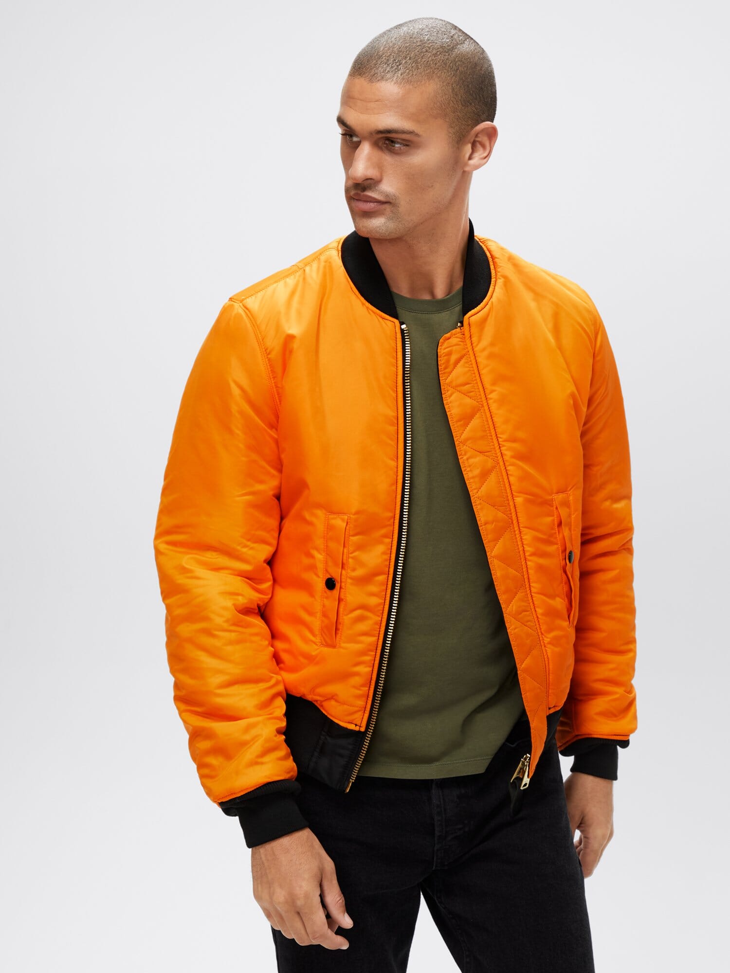 Three-quarter front view of orange reversible Alpha Industries MA-1 Bomber Jacket Slim Fit showing ribbed cuffs and waistband.