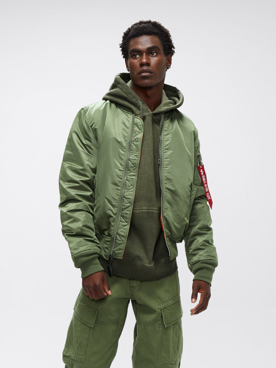 Full-body front view of sage green Alpha Industries MA-1 Bomber Jacket Slim Fit showing ribbed cuffs and orange lining.