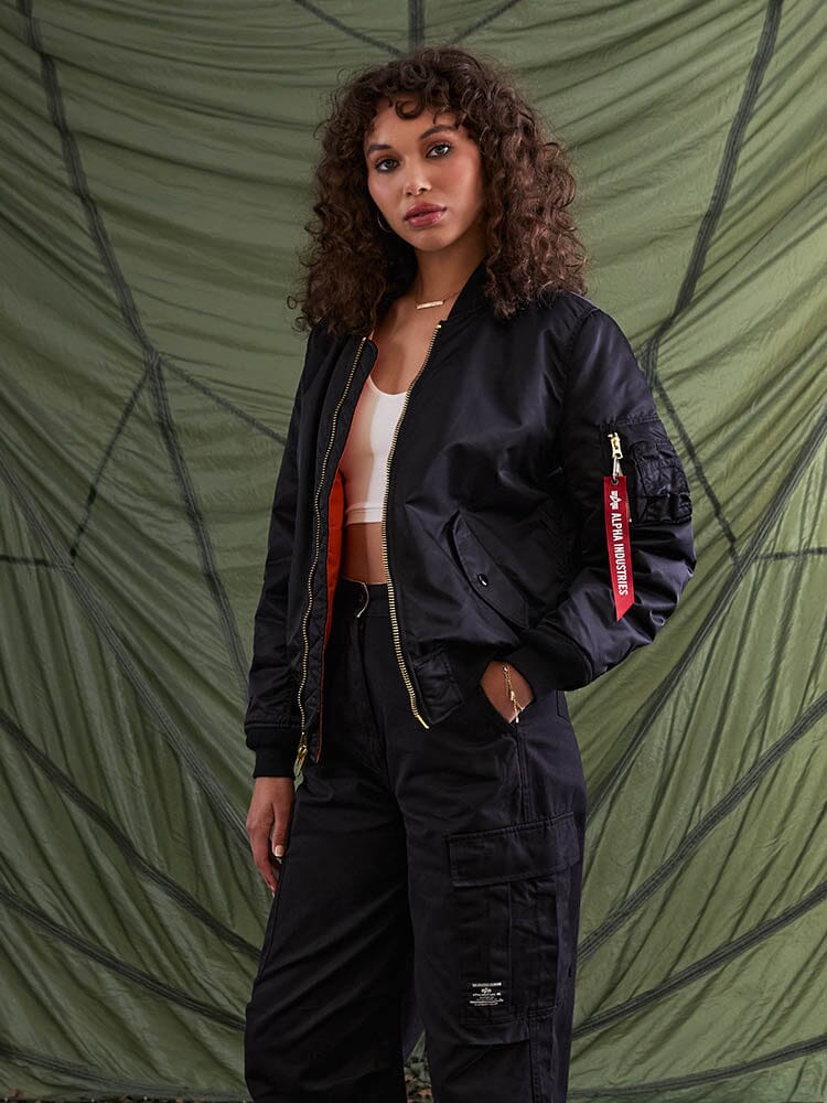 Alpha Industries MA-1 Bomber Jacket Womens in black, with a white crop top and black cargo pants.