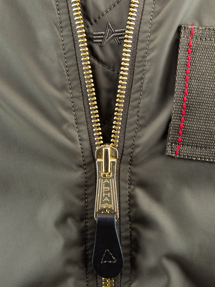 Alpha Industries MA-1 Skymaster Bomber Jacket, olive green, gold zipper, stitched patch in red thread, embroidered logo above the zipper.